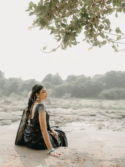 A serene solo portrait of the woman during our Makar Sankranti themed shoot. The black saree and traditional jewelry look stunning.