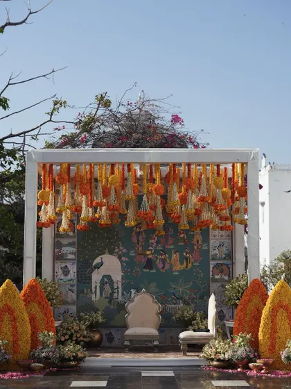 The full outdoor setup for the Pelikuthuru ceremony, showcasing the vibrant floral decor against the clear blue sky.