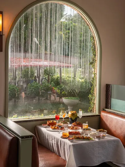 A table set for a monsoon lunch at Gallops, with rain streaming down the window. This shot beautifully captures a specific mood and experience, making the restaurant feel like a cozy haven.
