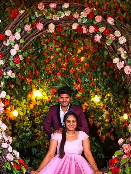 A beautiful pre-wedding shot in a floral archway. The light pink gown looks lovely against the backdrop of red and pink roses.
