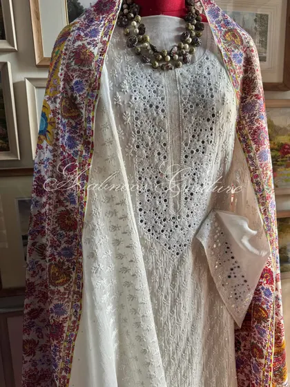 This image focuses on the graceful drape of the pure georgette Kashmiri Kalamkari dupatta over the shoulder, revealing the detailed embroidery of the suit beneath.