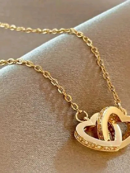 A beautiful necklace with two interlocking hearts, one polished and one studded with crystals. This piece symbolizes connection and love, making it a meaningful gift.