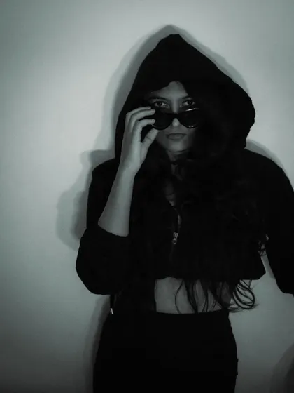 A mysterious, hooded look in monochrome. This shot plays with shadows and concealment to create a sense of intrigue, perfect for a dark feminine aesthetic.