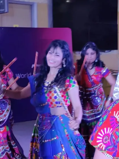 Leading the group in a Dandiya performance, with everyone dressed in colorful traditional attire.