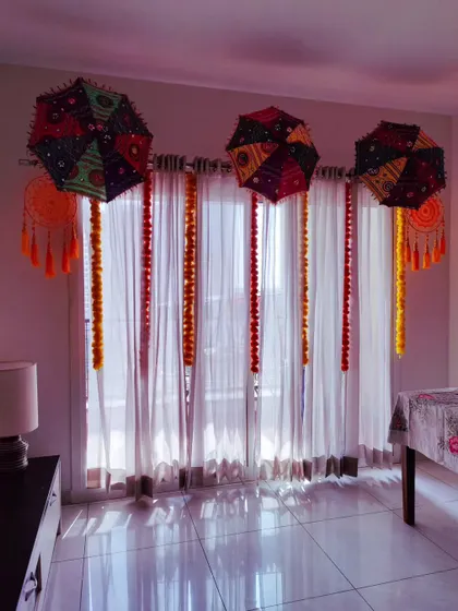 A festive Lohri decor setup for an at-home celebration. I use colorful umbrellas, marigold garlands, and dreamcatchers to bring the festive spirit to your space.