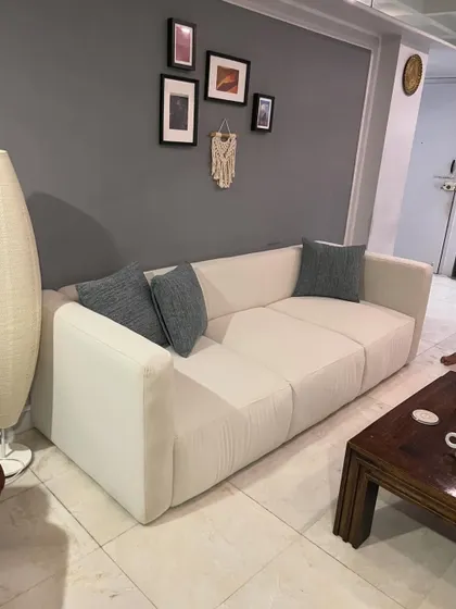 The same modern sofa design placed in a client's home, showing how it integrates seamlessly into a living room setting.