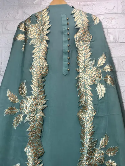 A close-up of a stunning teal-green dupatta with heavy gold leaf-patterned embroidery. I can create custom dupattas like this to elevate any simple kurta set.