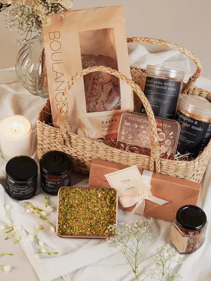 A charming Rakhi gift presented in a rustic wicker basket. This hamper includes a variety of our gourmet snacks, dips, and a loaf of fresh bread, perfect for a celebratory brunch.