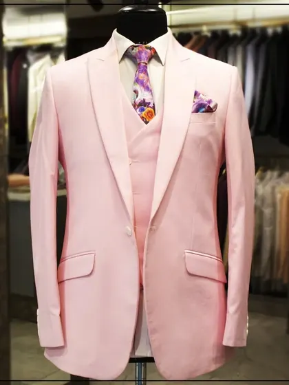 A still shot of the light pink three-piece suit on a mannequin, showcasing its clean cut and modern color.