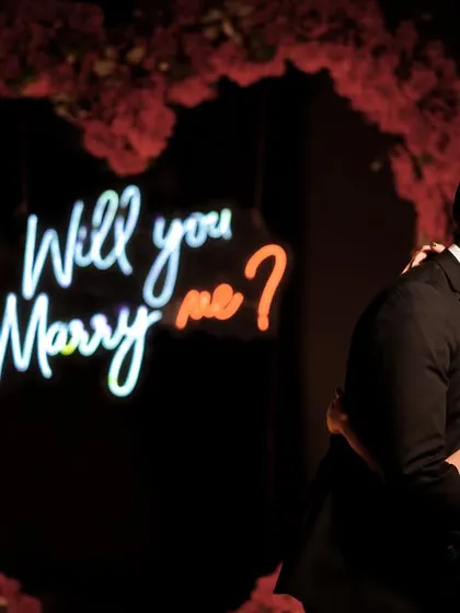 A close-up of the kiss that sealed the deal, with the neon sign in the background.