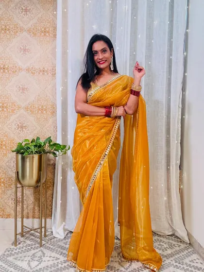 This yellow organza saree with a mirror-work border is perfect for a Haldi or Mehendi ceremony. It's bright, festive, and lightweight.