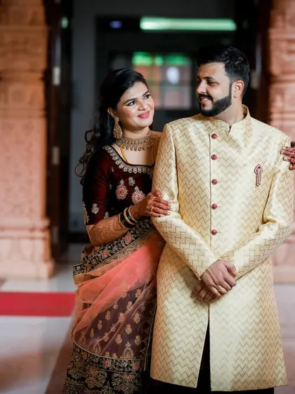 A classic couple portrait. The bride and groom stand together in their reception attire, framed by the venue's grand architecture.