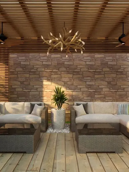 An inviting outdoor patio I designed, featuring a stone accent wall and a slatted wood pergola. This space was created to be a perfect extension of the home, blending comfort with natural elements for relaxation.