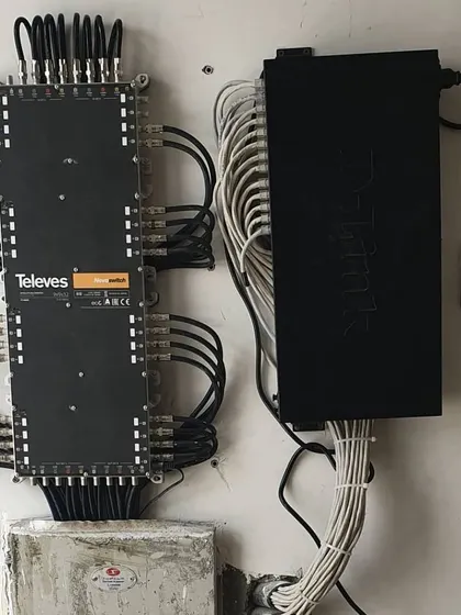 A professional setup using a Televes multiswitch and a Tiandy network switch. This shows a clean installation with organized cable management for a large system.