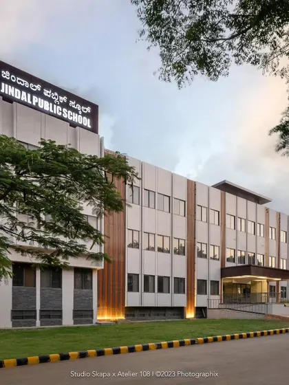 The facade of Jindal Public School, where we introduced earth-toned vertical rafters to break the monotony of the textured grey exterior. These rafters also cleverly conceal ventilators and service ducts while adding aesthetic appeal with subtle lighting.