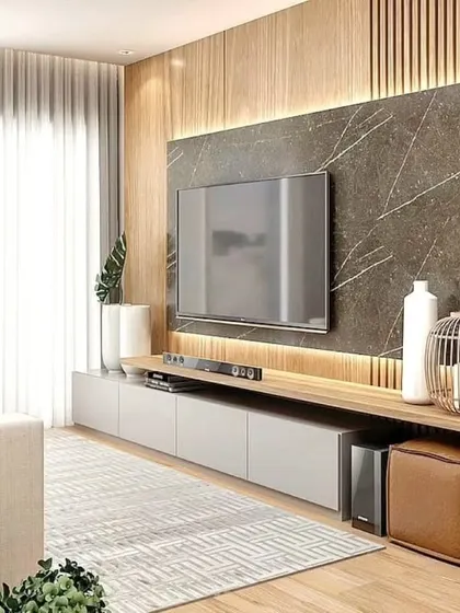 A living room design that feels open and connected to the outdoors, with a large window, light wood flooring, and a modern TV unit.