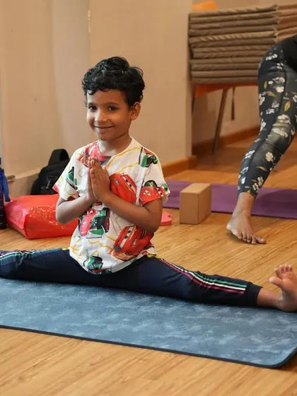 Look at that smile. This student finds joy and accomplishment in achieving Hanumanasana (the splits), a pose that requires both flexibility and patience.