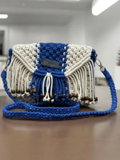 A stunning combination of royal blue and off-white in this fringed sling bag. The wooden beads complete the boho-inspired look.