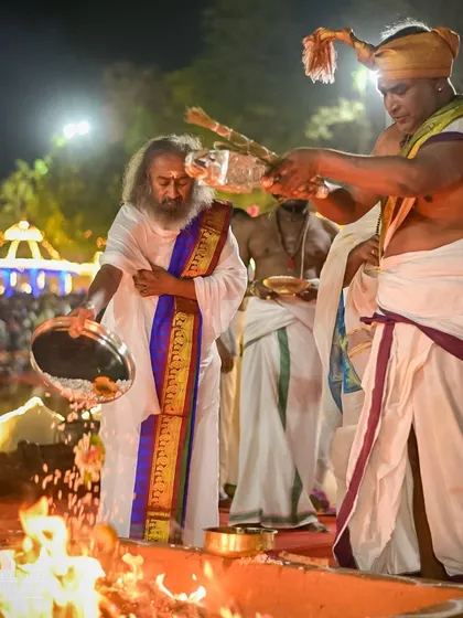 I am making an offering into the fire during the Maha Rudra Homa. This powerful ceremony is a highlight of our all night Shivratri celebration, generating immense positive energy.