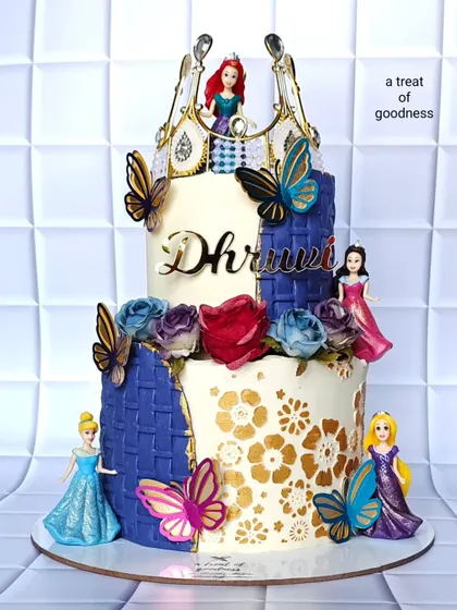 A princess theme can be both magical and elegant. This two-tiered design for a young dreamer features a purple basket-weave texture, gold stenciling, and figurines of her favorite princesses, proving that kids' cakes can be sophisticated too.