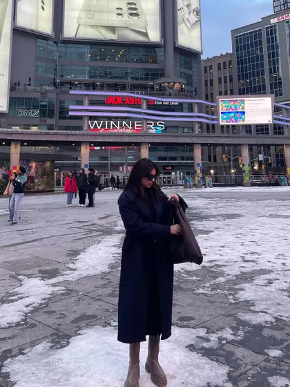 A candid shot in a Shein trench coat while exploring downtown Toronto in the winter.
