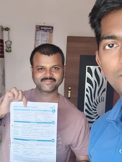 Our team member with a customer holding his new solar agreement. Another step towards a greener India.