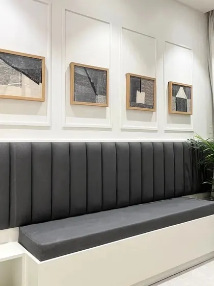 This dining unit offers both style and functionality with a long, comfortable bench seat that provides extra seating and hidden storage. The dark grey upholstery is paired with abstract art for a modern look.