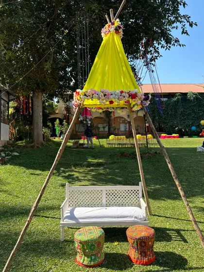 We created this charming teepee tent seating for the bride during her Mehandi. The yellow drapes and floral accents make it a unique and fun focal point for the celebration.