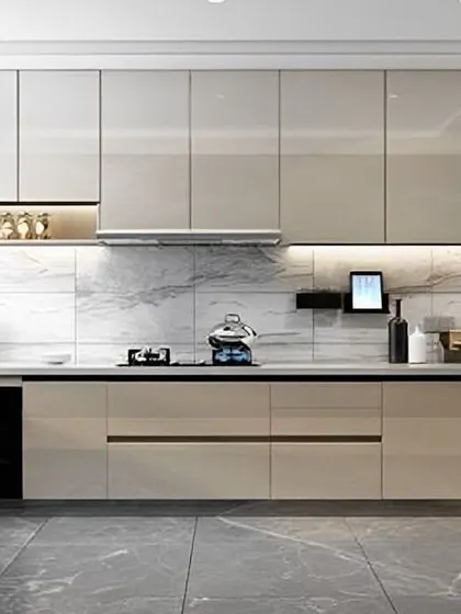 A luxurious U-shaped kitchen with high-gloss beige cabinets and a marble backsplash. Integrated lighting under the upper cabinets and inside the glass display shelves adds a layer of sophistication.