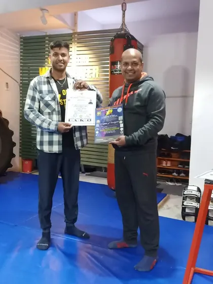 Coach Sandeep proudly holding his 1st Dan Black Belt and National Referee certifications.