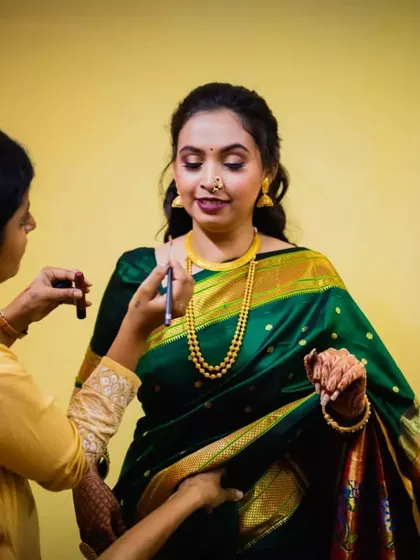 A candid moment of me applying the final touches. The bride is wearing a beautiful green saree, and her makeup is kept soft and glowing for her engagement ceremony.