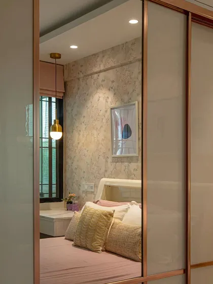 A view of the 'Sisterly Chic' bedroom reflected in the sliding wardrobe mirror. The use of mirrors is a strategic choice to enhance the sense of space.