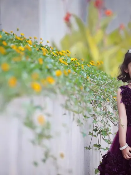 A lovely portrait of the birthday girl in a garden setting. The natural flowers and greenery create a beautiful, soft background.