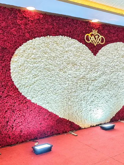 A slightly different angle of the heart-shaped floral wall, showing how the uplighting enhances its texture and color. This romantic backdrop is one of my signature offerings for weddings and engagements.