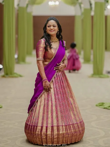 Full-length shot of the pink and purple langa voni, showing the beautiful pleats and rich silk fabric.