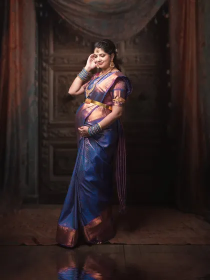 Wrapped in tradition, adorned in love. Every fold of this blue silk saree carries the blessings of generations, and every smile holds a story.