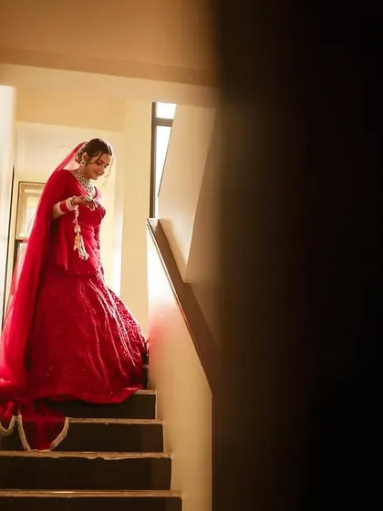 A dramatic shot of the bride descending the stairs, creating a sense of anticipation for her big moment.
