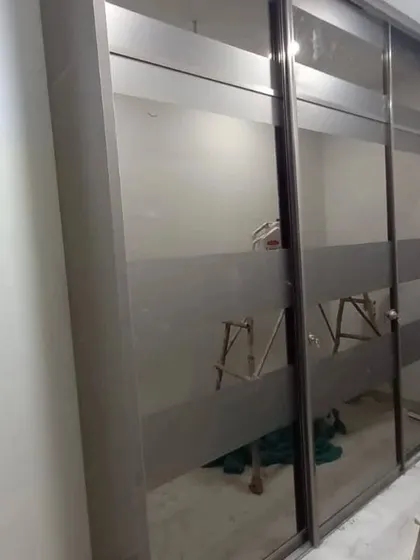 An installed Aristo sliding wardrobe with frosted glass panels. This type of wardrobe is both beautiful and functional, perfect for modern bedrooms where space is a premium.