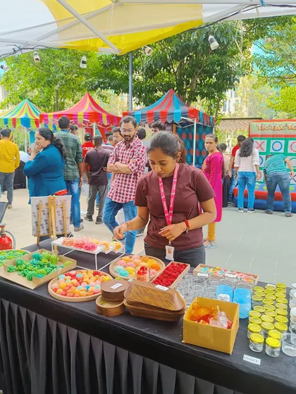 A participant at our live booth at Eco Space selects from a wide array of colorful wax embeds to decorate her candle.