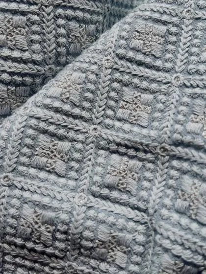 A close-up of our embroidered Georgette Lucknowi fabric. The dense, textured embroidery in a geometric pattern gives it a rich and traditional feel.