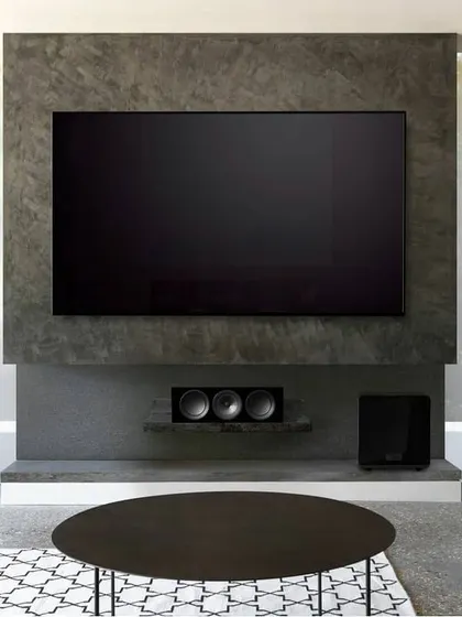 This modern living room features a full KEF surround sound system. The slim tower speakers, matching center channel, and subwoofer are arranged to provide an immersive soundstage for movies, all while maintaining a clean, minimalist look.