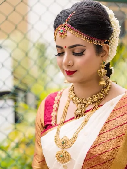 A classic bridal pose showing off the flawless makeup. The focus is on the perfectly winged eyeliner and bold red lip, a timeless combination for any bride.