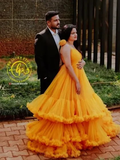 A classic pre-wedding pose. I styled the groom in a timeless black suit that allows the bride's vibrant yellow ruffled gown to truly shine.