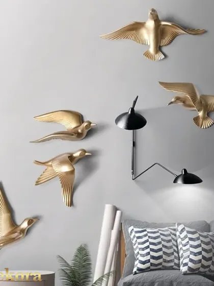 A set of five metal birds, shown here in a living room, adding a simple yet elegant natural touch.