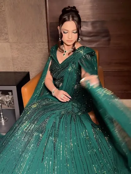 Capturing the movement and shimmer of a Gaurav Gupta creation. The makeup was designed to match this energy, with a focus on glowing skin and dramatic eyes that complement the emerald green gown for a show-stopping cocktail look.