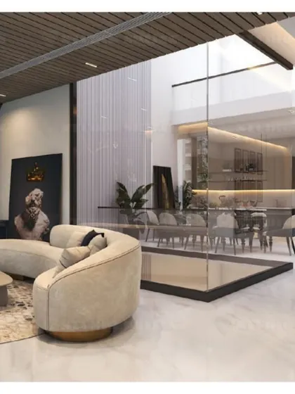 A double-height section of the Mansarovar Garden lobby, with a glass partition that creates a sense of openness while defining the dining space.