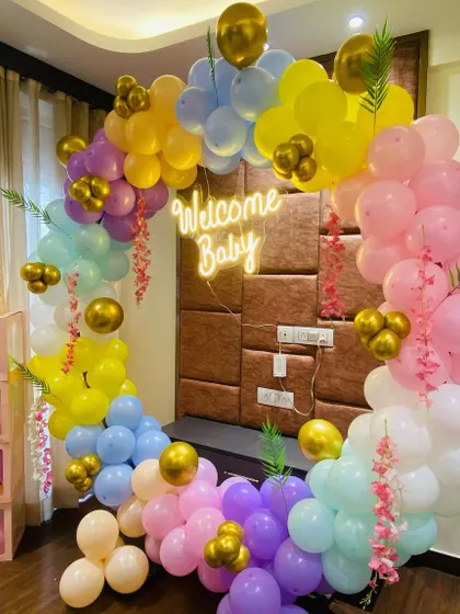 The pastel rainbow "Welcome Baby" setup, also featuring transparent "BABY" blocks filled with balloons.