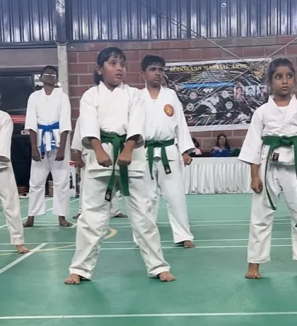 A group of young students standing ready for the next command. Their posture and attention show the discipline instilled through karate.