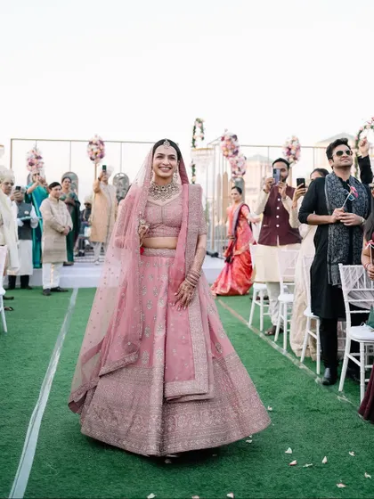The bride's radiant smile as she walks down the aisle, with all eyes on her. A moment of pure grace and happiness.