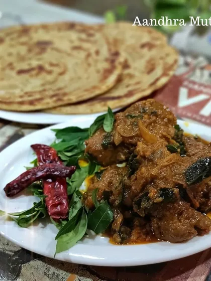 Another look at our spicy Andhra Mutton, garnished with fresh curry leaves and whole red chillies. A must-try for those who love bold flavors.